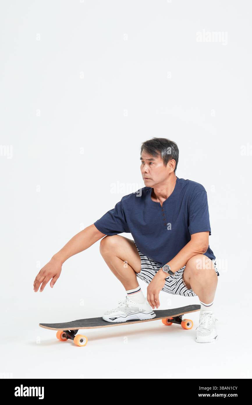 Un vieil homme faisant du skateboard Banque D'Images