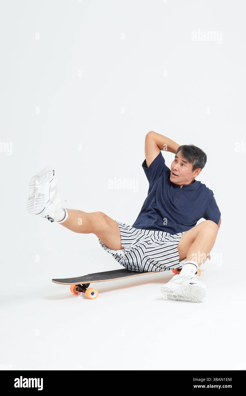 Un vieil homme faisant du skateboard Banque D'Images