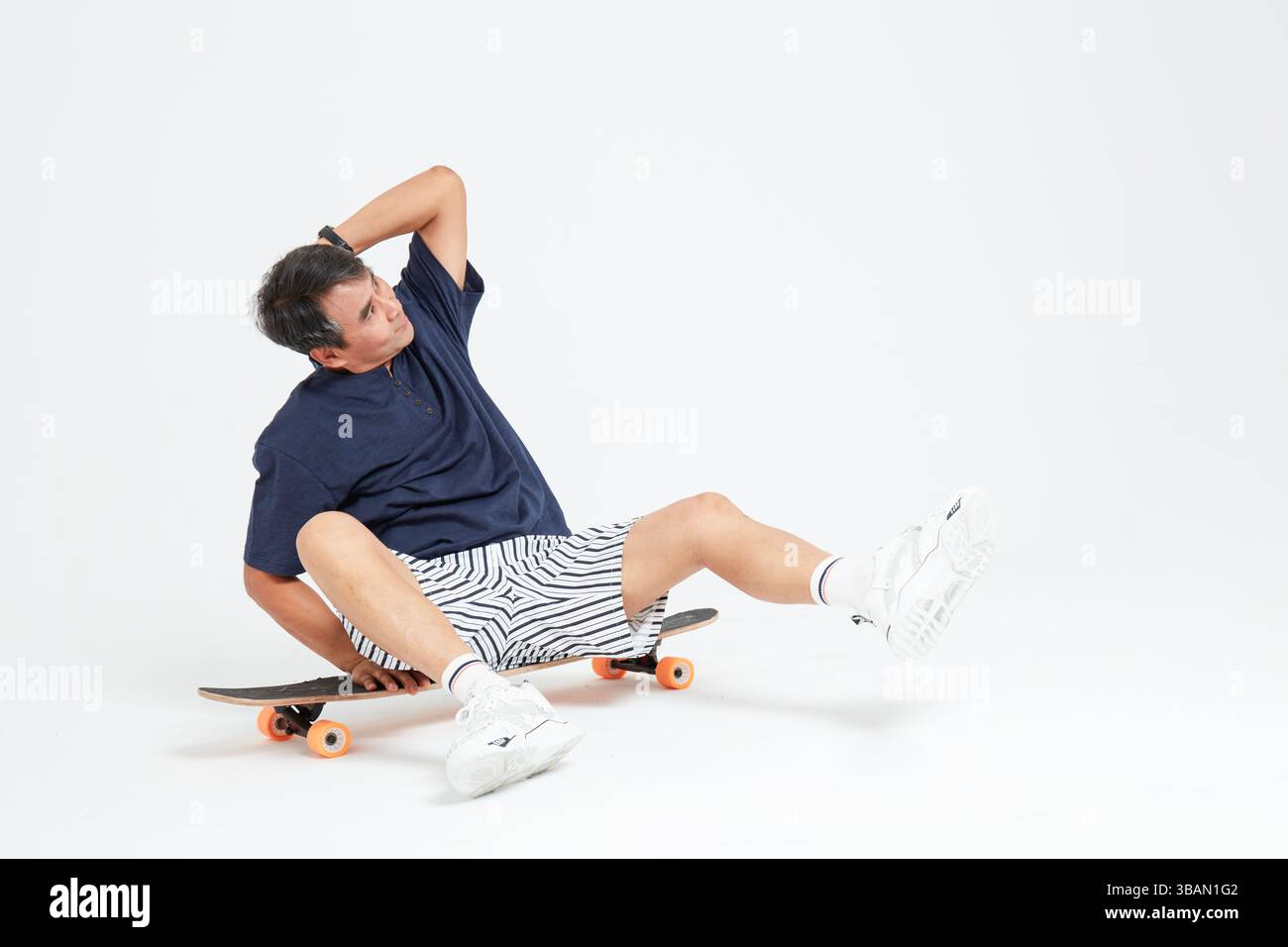 Un vieil homme faisant du skateboard Banque D'Images