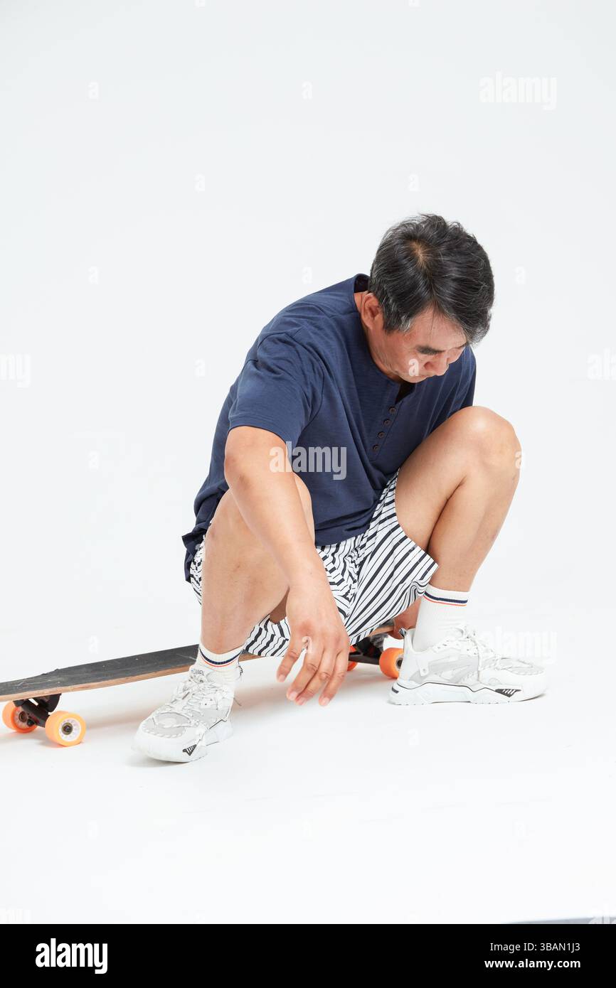 Un vieil homme faisant du skateboard Banque D'Images