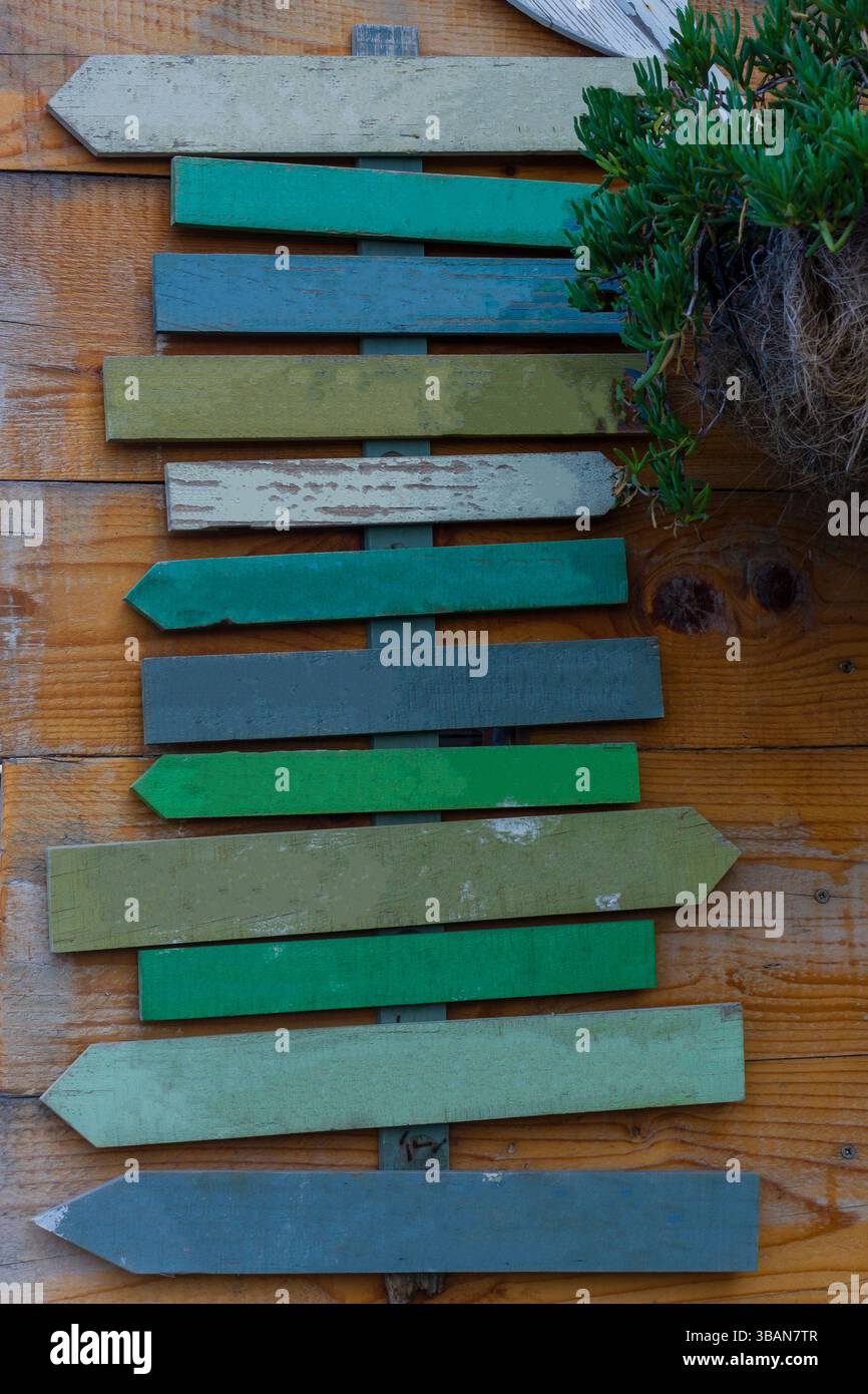 Panneau de direction de flèche en bois coloré sur fond en bois rustique Banque D'Images