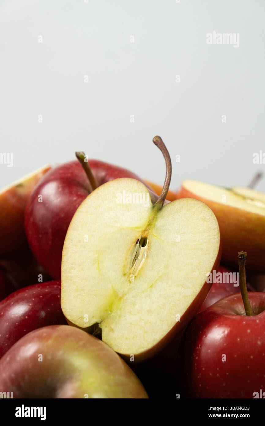 Groupe de pommes entières rouges fraîches et de moitiés de pommes en gros plan. Banque D'Images
