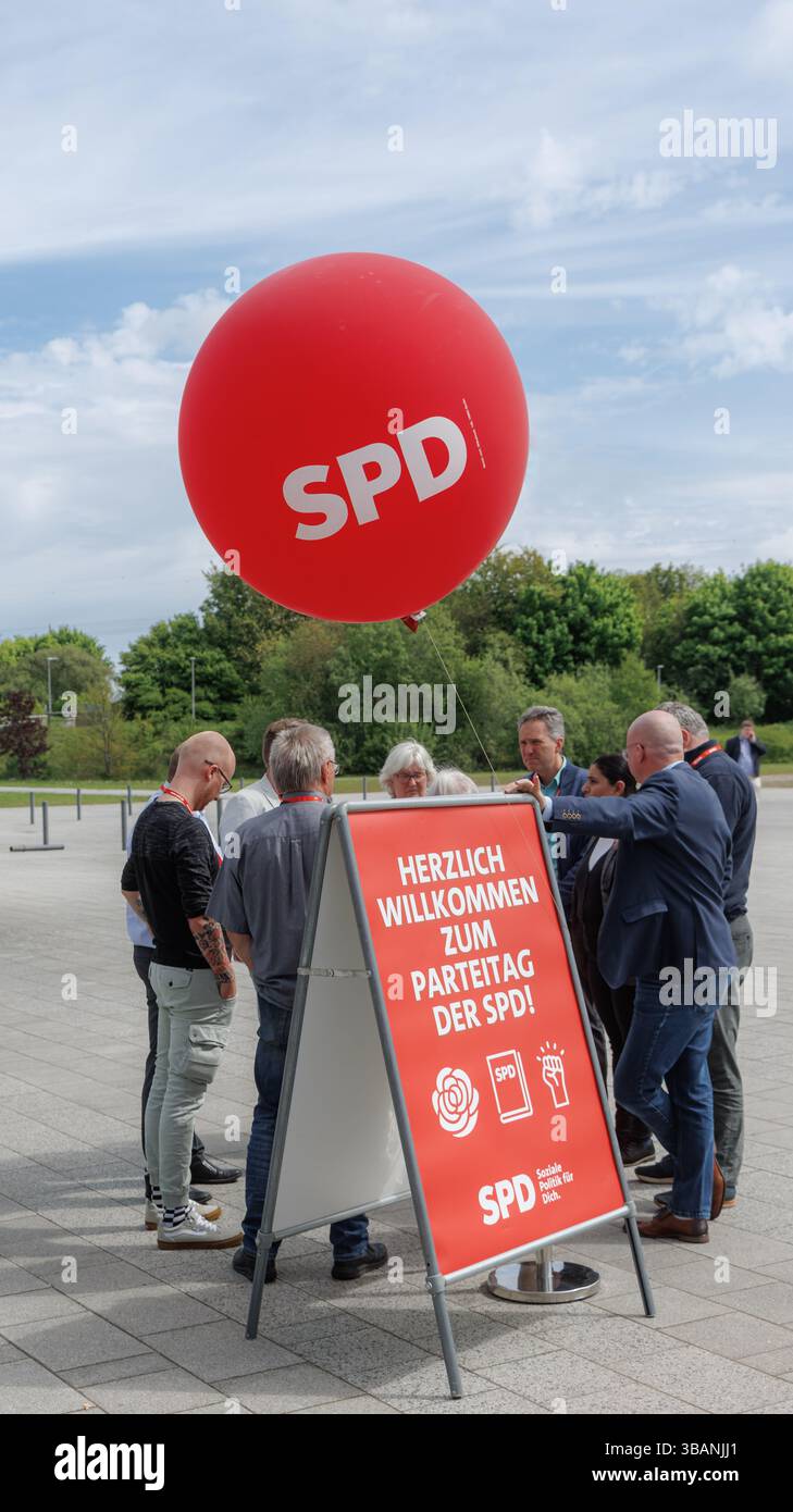 Husum, Allemagne. 10 mai 2025. Un ballon portant le logo « SPD » flotte au-dessus des membres du groupe debout ensemble pendant une pause dans la réunion. Crédit : Markus Scholz/dpa/Alamy Live News Banque D'Images