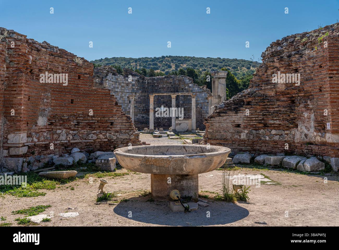 Bassin baptismal circulaire situé entre les murs de briques rouges de l'église Sainte-Marie, l'une des premières cathédrales chrétiennes construites dans l'ancienne Éphèse. Banque D'Images