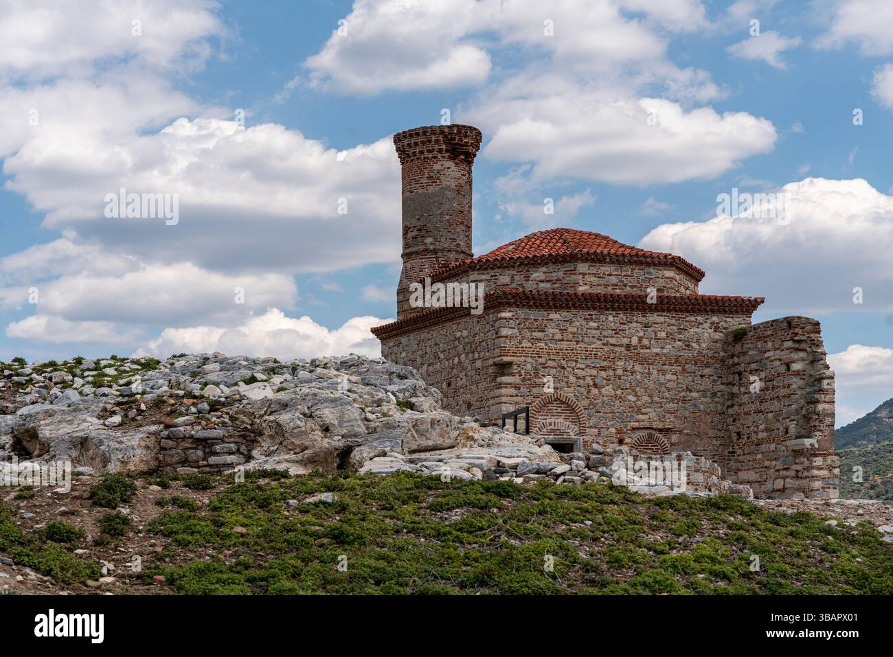 Les ruines de Kale Camii se dressent sur une colline rocheuse à Selcuk, avec des nuages spectaculaires et des pierres anciennes entourant la structure historique de la mosquée. Banque D'Images