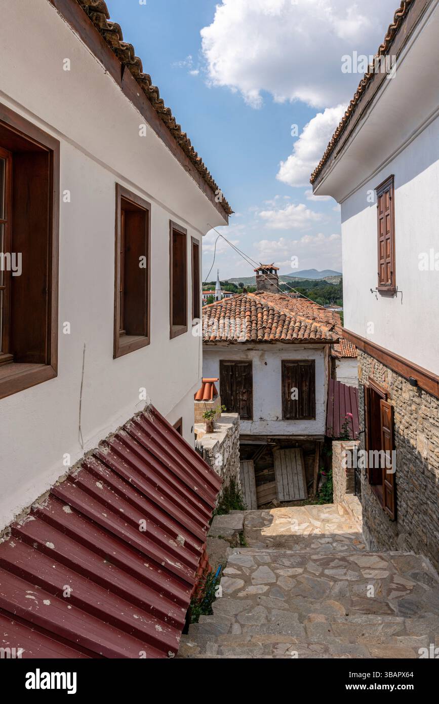 Une étroite rue pavée de Sirince, bordée de maisons blanchies à la chaux et de toits de tuiles rouges, capture le charme pittoresque de ce village de montagne turc Banque D'Images
