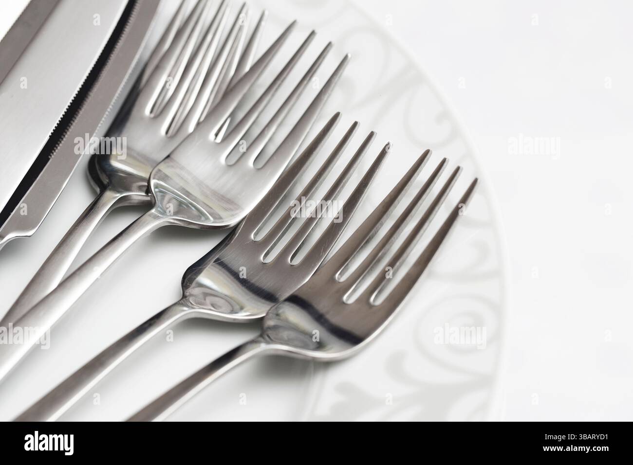 Fourchettes argentées sur assiette en porcelaine. Table élégante pour un dîner formel. Arrangement de couverts classique. Fond de cuisine raffinée. Banque D'Images
