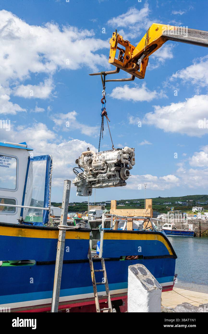Nouveau moteur de bateau installé sur un bateau de tourisme par grue, Portmagee, comté de Kerry, Irlande Banque D'Images