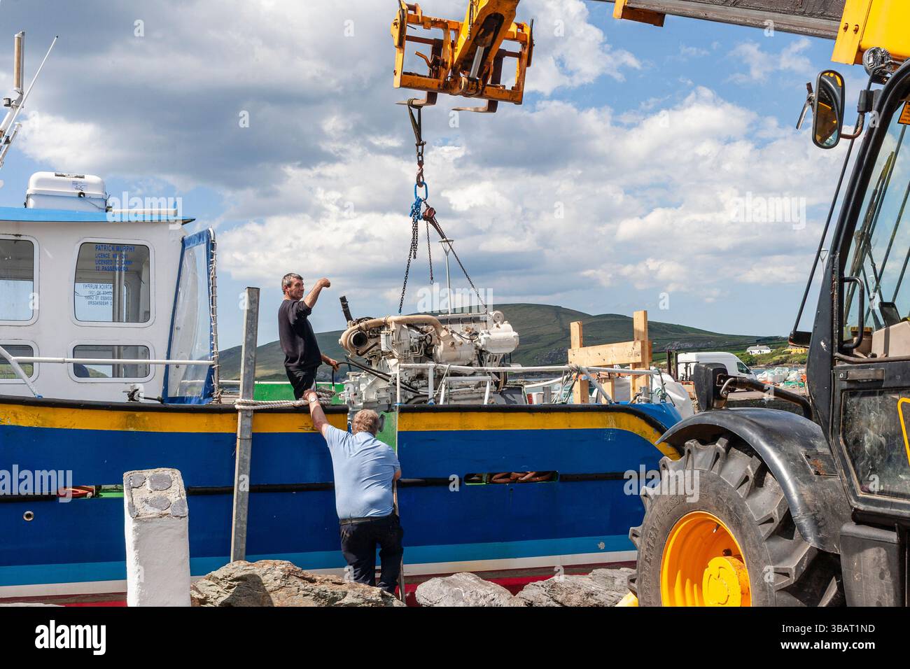 Nouveau moteur de bateau installé sur un bateau de tourisme par grue, Portmagee, comté de Kerry, Irlande Banque D'Images