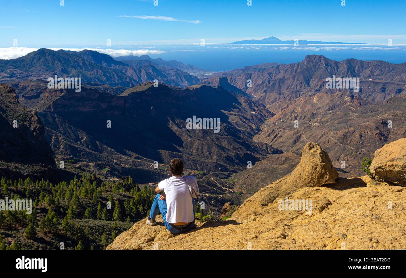 Jeune randonneur contemplant le panorama pittoresque des montagnes volcaniques et du teide depuis le point de vue de roque nublo à gran canaria Banque D'Images