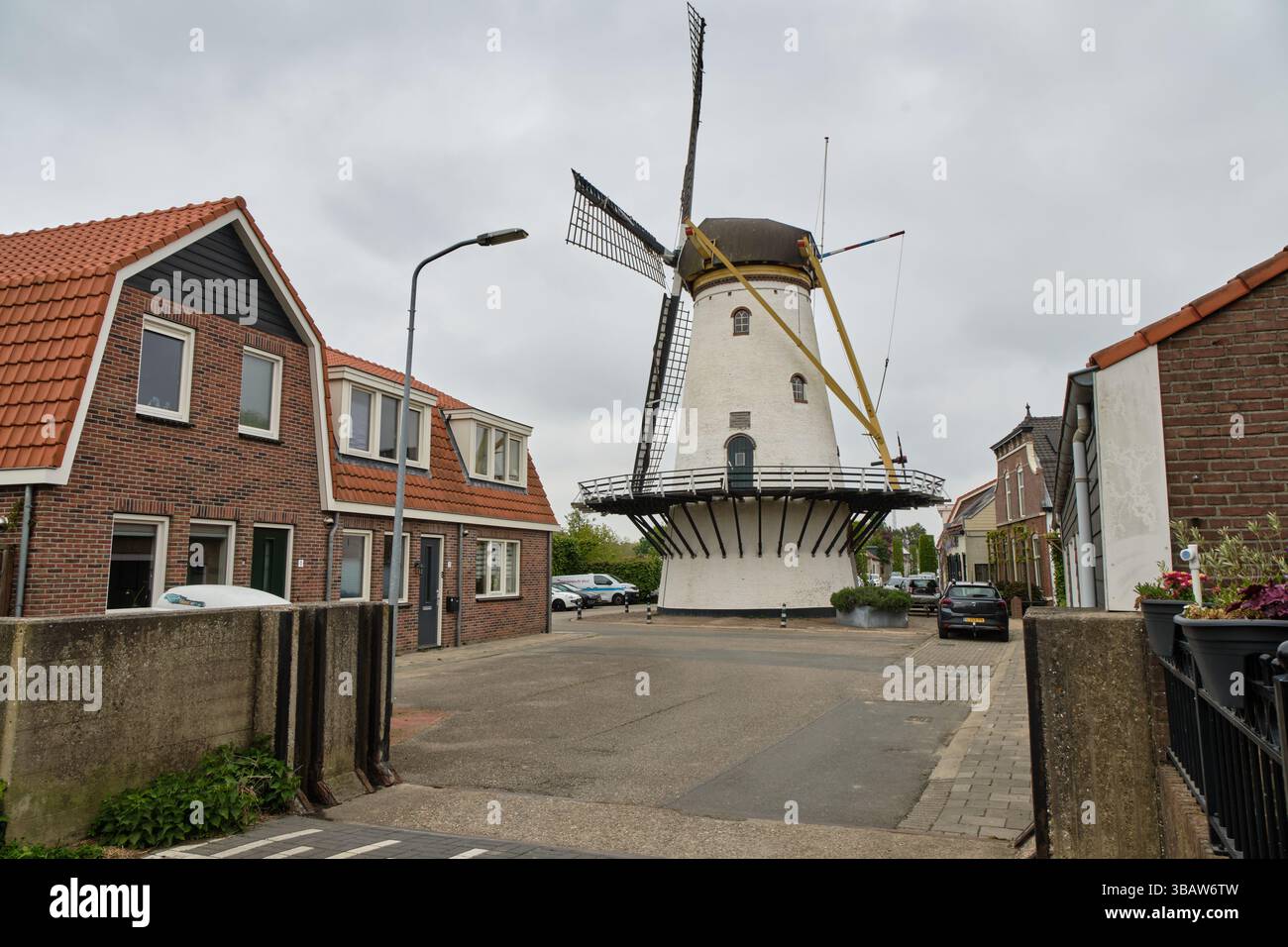 24 avril 2025 - Stellendam-pays-Bas : moulin à vent traditionnel Korenlust avec tour blanche et chapeau noir situé près du vieux port de Stellendam. Banque D'Images