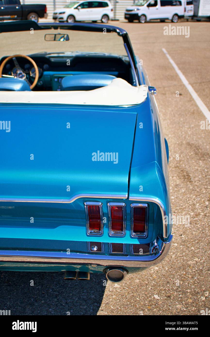 Vue arrière d'un cabriolet Ford Mustang bleu classique avec trois feux arrière emblématiques et pare-chocs chromés Banque D'Images
