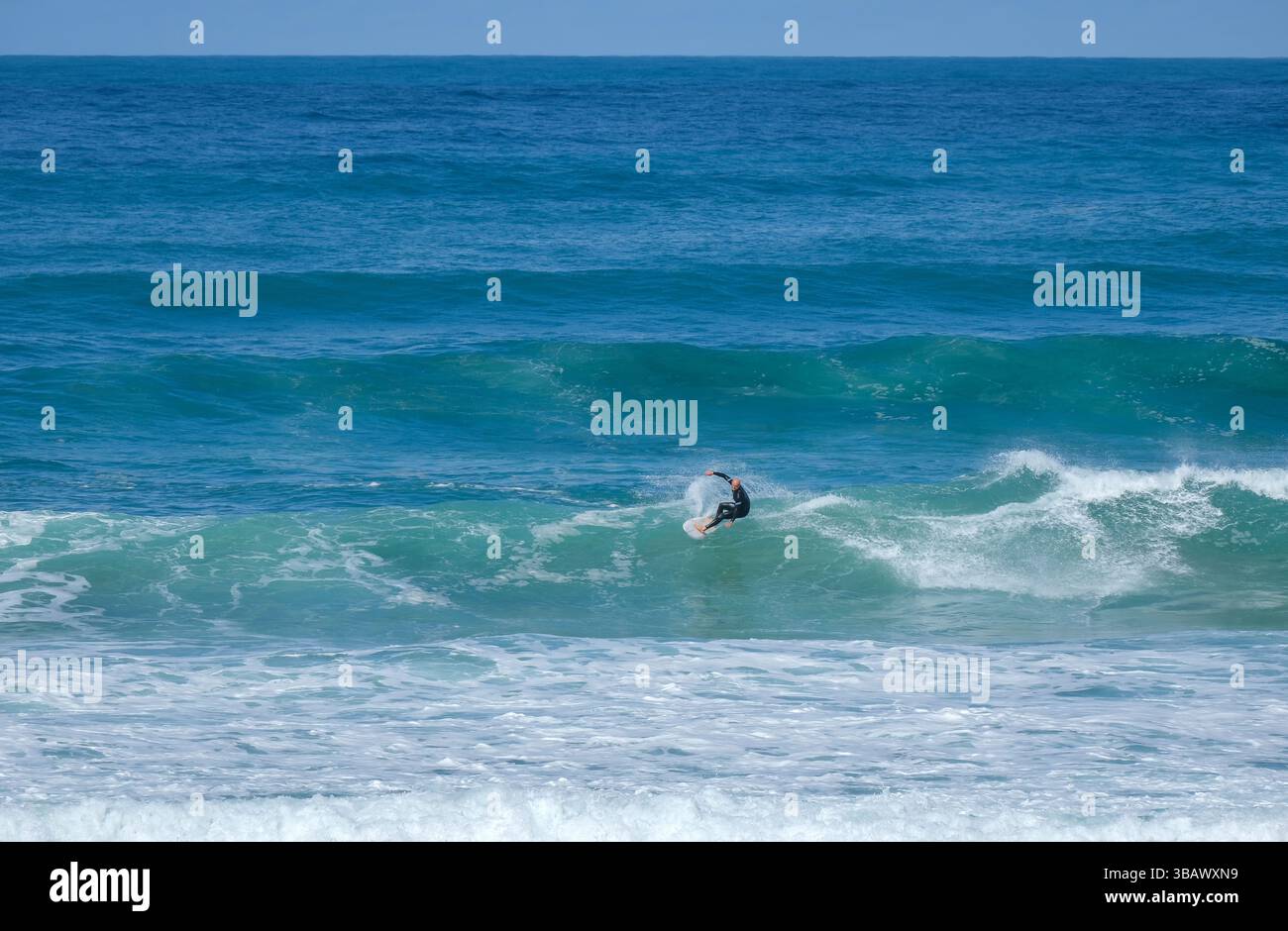 28.02.2025, Portugal, Algarve, Vila do Bisbo - surfeurs dans les vagues à Ponta Ruiva Beach. Praia da Ponta Ruiva, belle plage de sable isolée sur le Banque D'Images