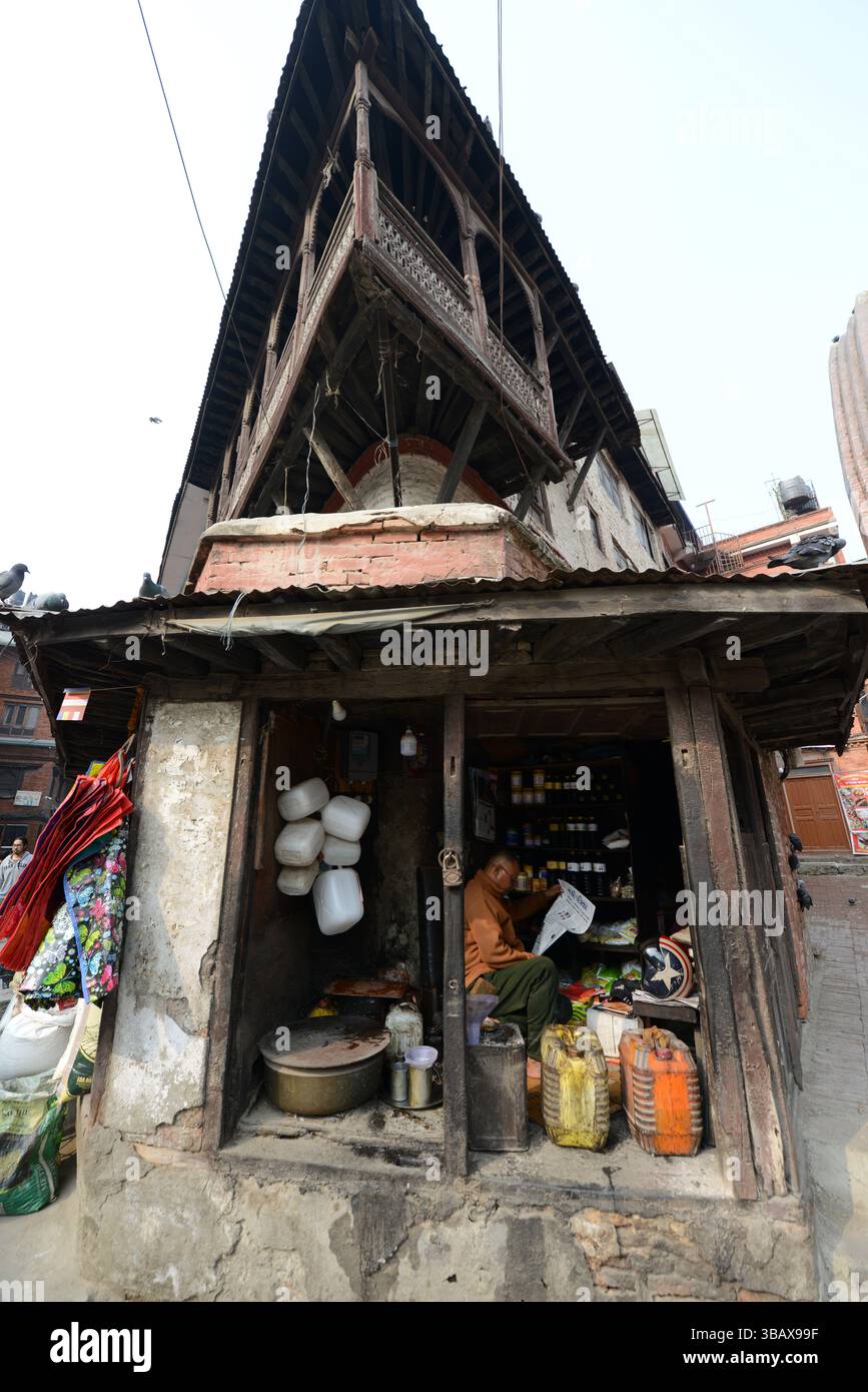 Un marchand népalais lisant le journal du matin à Basantapur, Katmandou, Népal. Banque D'Images