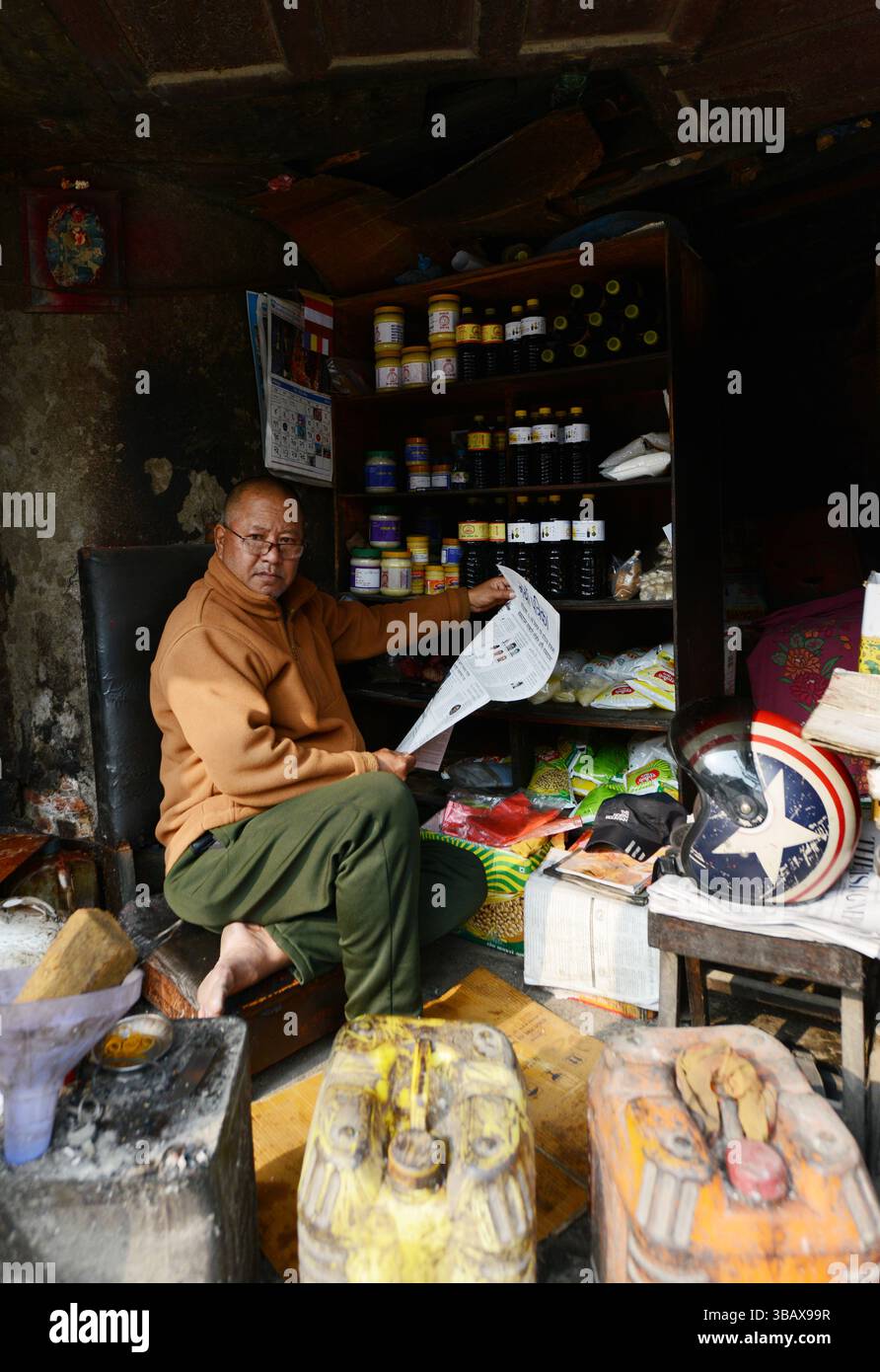 Un marchand népalais lisant le journal du matin à Basantapur, Katmandou, Népal. Banque D'Images