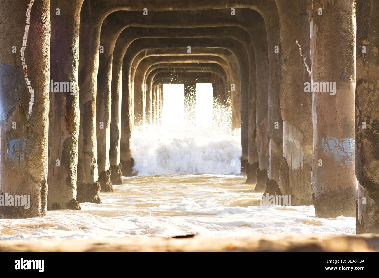 Les vagues se brisent sous la jetée de Manhattan Beach Banque D'Images