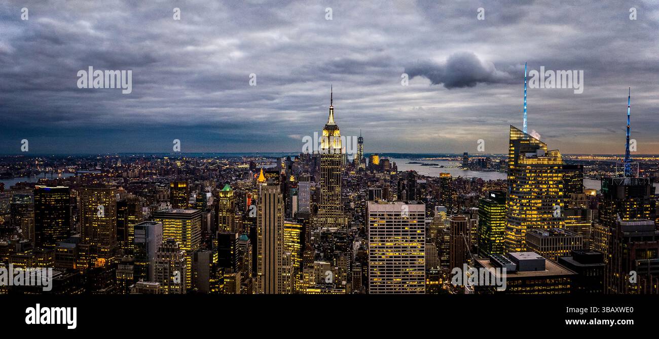Vue panoramique de New York City au crépuscule, avec l'Empire State Building et des gratte-ciels brillants, photographiés depuis Top of the Rock. Banque D'Images