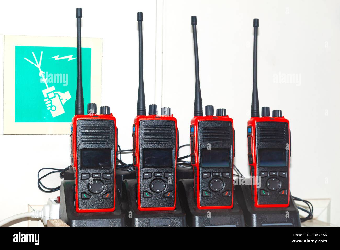 De nombreux talkies-walkies se tiennent dans les chargeurs et se chargent. Banque D'Images
