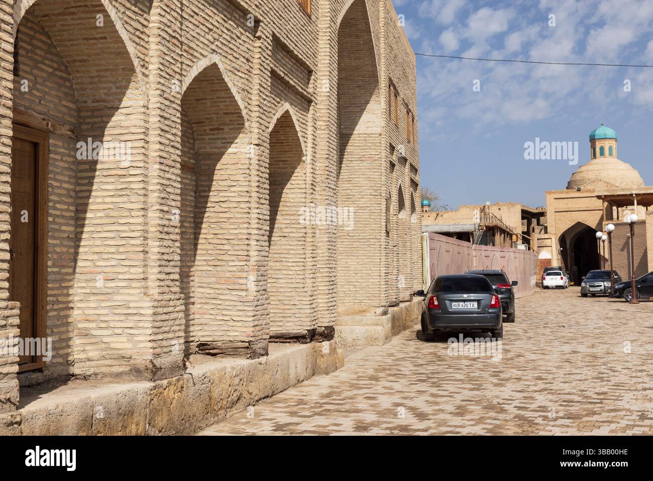 Boukhara, Ouzbékistan - 27 mars 2024 : vue sur la rue mettant en valeur l'architecture historique avec des murs de briques traditionnels, des caractéristiques voûtées et une ruelle tranquille Banque D'Images