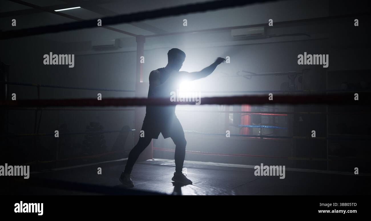 Personne, silhouette et boxe dans l'anneau pour l'entraînement, le punch et la puissance avec la routine pour les sports de combat. Athlète, combattant et arts martiaux mixtes avec Banque D'Images