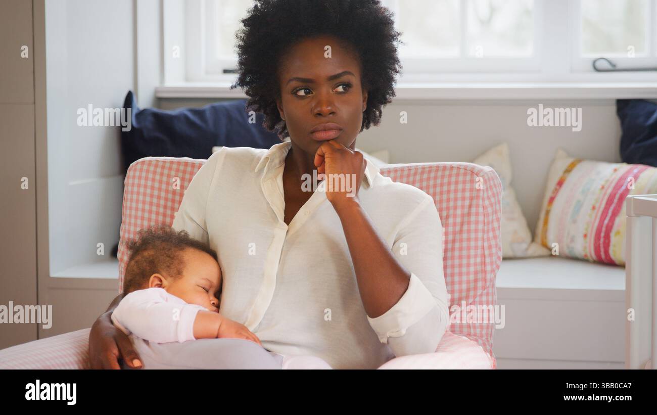 Nouvelle mère souffrant de dépression post-natale tenant la fille de bébé endormi dans la pépinière à la maison Banque D'Images