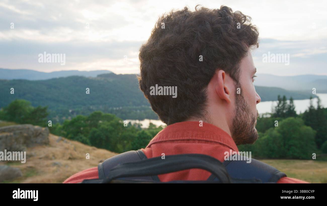 Gros plan sur Young Man Standing at Top of Hill en randonnée à travers la campagne dans Lake District UK Banque D'Images