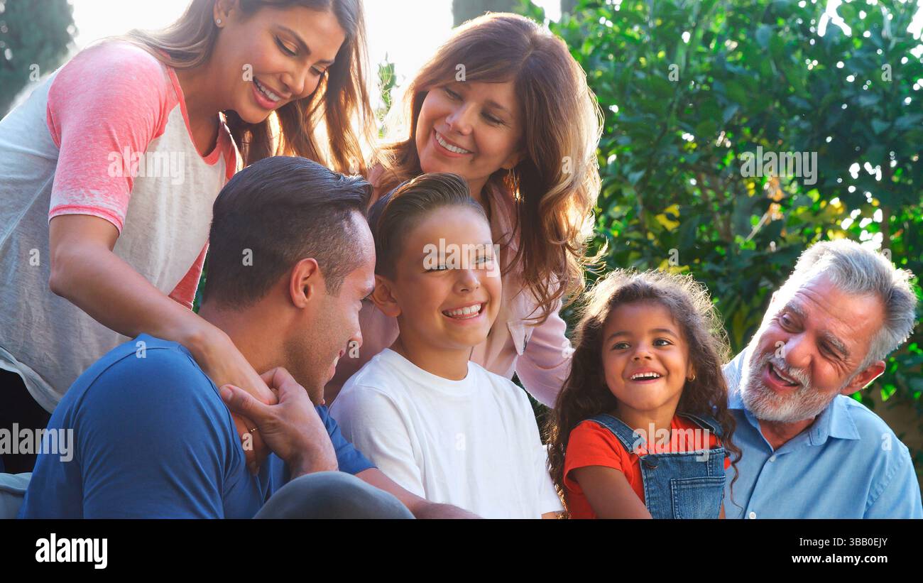 Famille hispanique multi-génération détente dans Garden at Home ensemble Banque D'Images