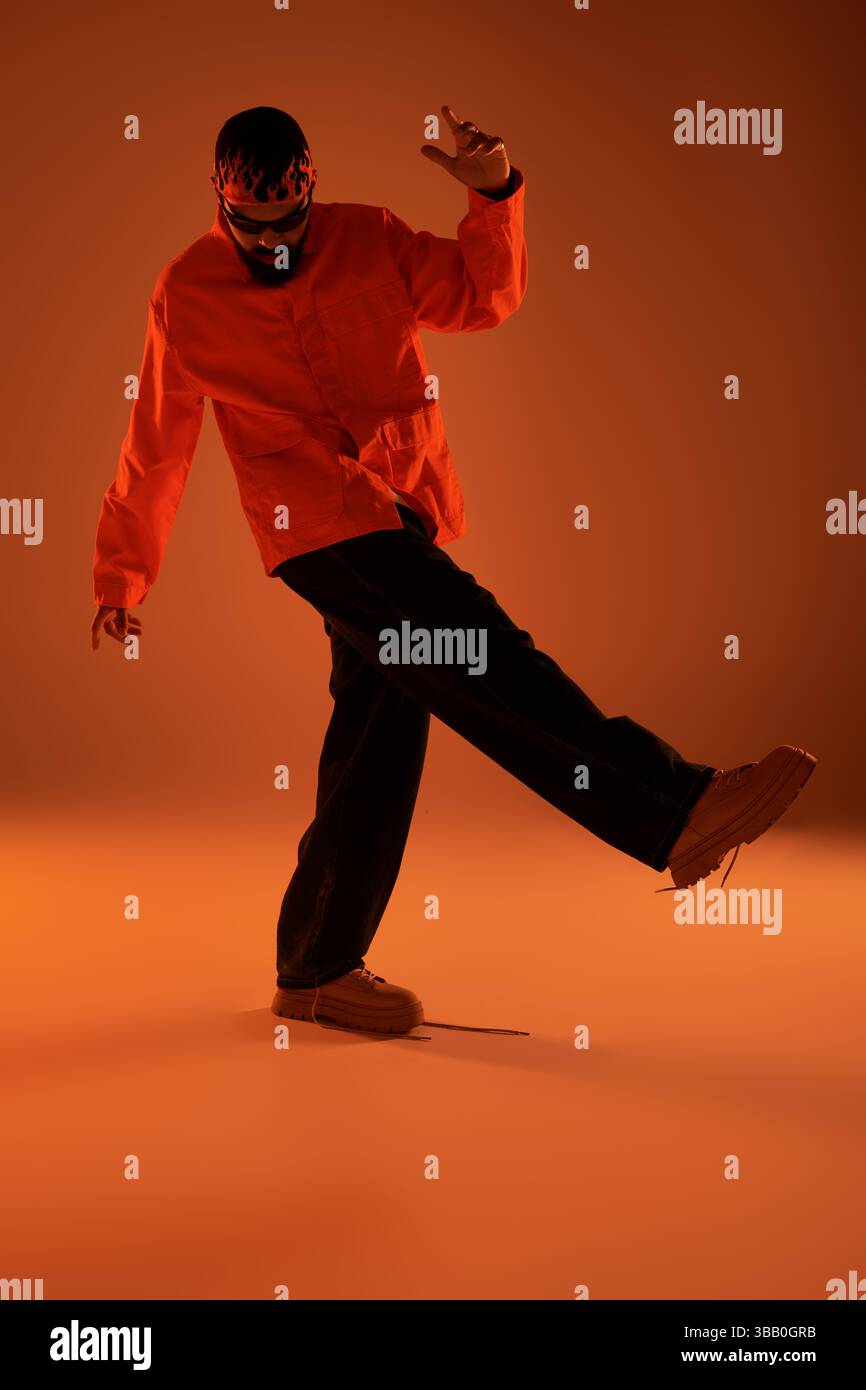 Un jeune homme élégant met en valeur son esthétique estivale tout en interagissant avec une lumière captivante. Banque D'Images