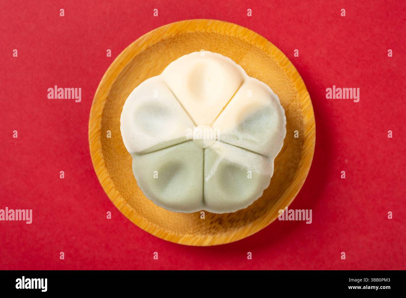 vue de dessus forme de fleur blanc et vert clair mooncake sur rouge Banque D'Images