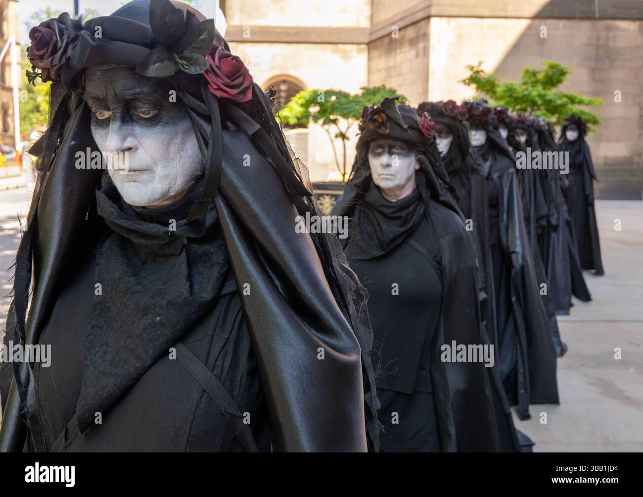 Manchester, Royaume-Uni. 14 mai 2025. Les « nappes d'huile » marchent de la bibliothèque centrale de Manchester au mémorial du massacre de Peterloo à Manchester Central. Manifestation de la rébellion extinction devant la conférence Biba 2025 Insurance où les membres de la rébellion extinction protestaient à Manchester Central. Les manifestants ont montré des photos des victimes des inondations au Royaume-Uni aux participants à la conférence. Un modèle Lamborghini « coulant » a été installé où des fusées éclairantes ont été déclenchées. Crédit : GaryRobertsphotography/Alamy Live News Banque D'Images