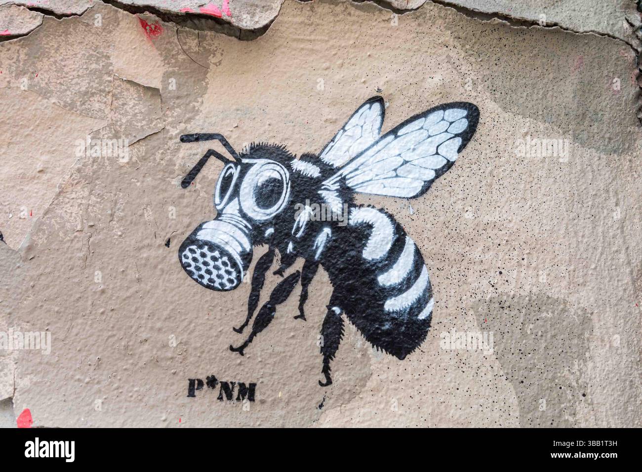Street art de Montmartre : abeille, petit graffiti au pochoir de P*NM dans le 18ème arrondissement de Paris, France. Banque D'Images