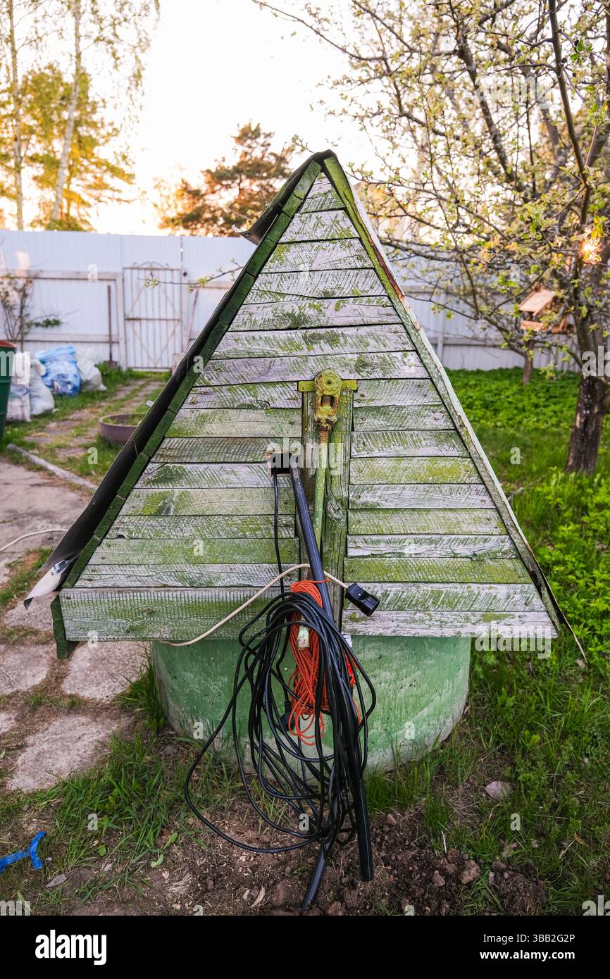 moscou, russie, 10.05.2025 Une structure en bois avec un toit triangulaire est recouverte de mousse. Un fil est fixé au toit Banque D'Images