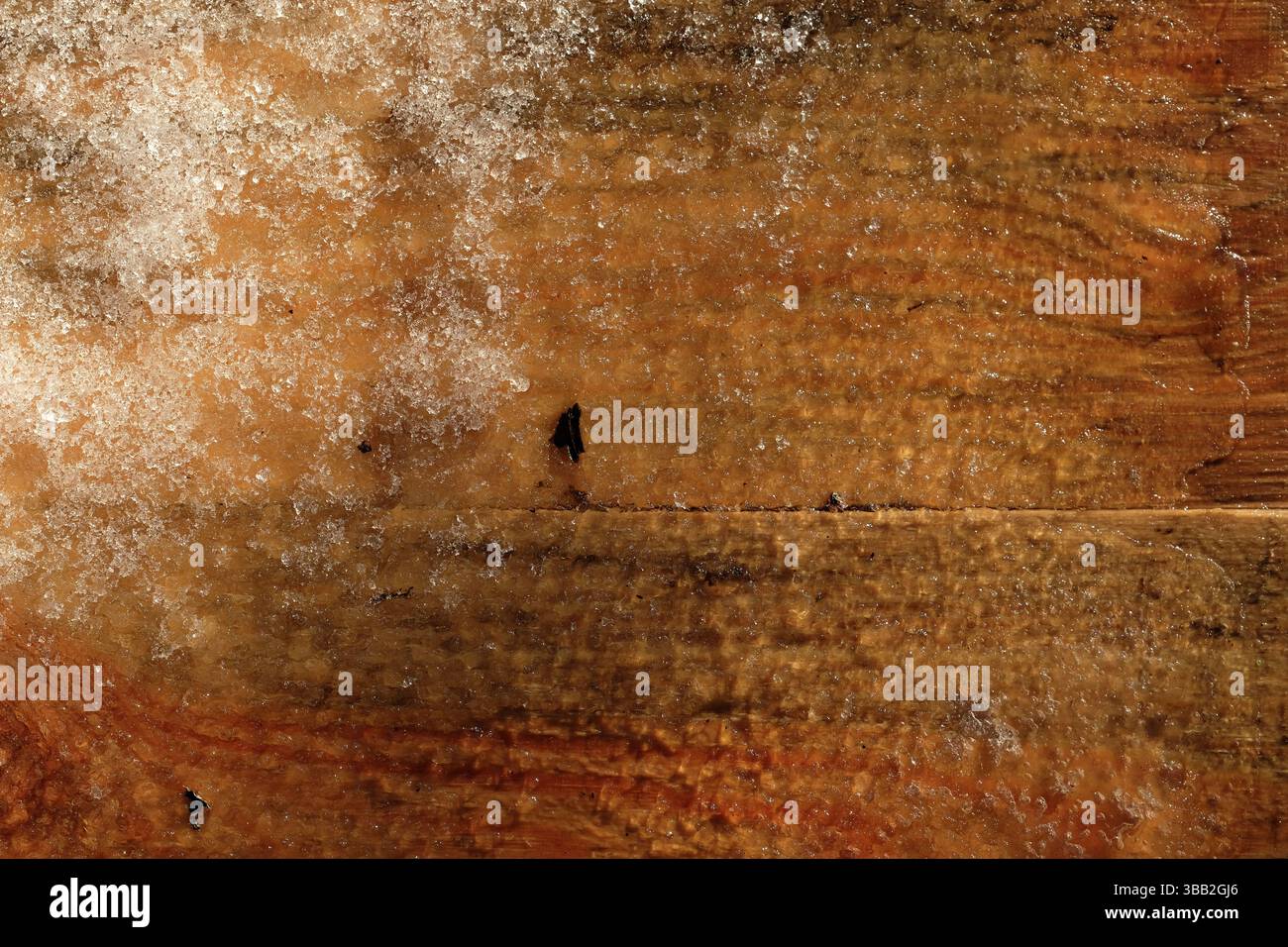 Planche de pin humide sous la neige. Fond en bois pour la conception. Surface en bois de couleur chaude, brun rougeâtre avec texture naturelle. Banque D'Images