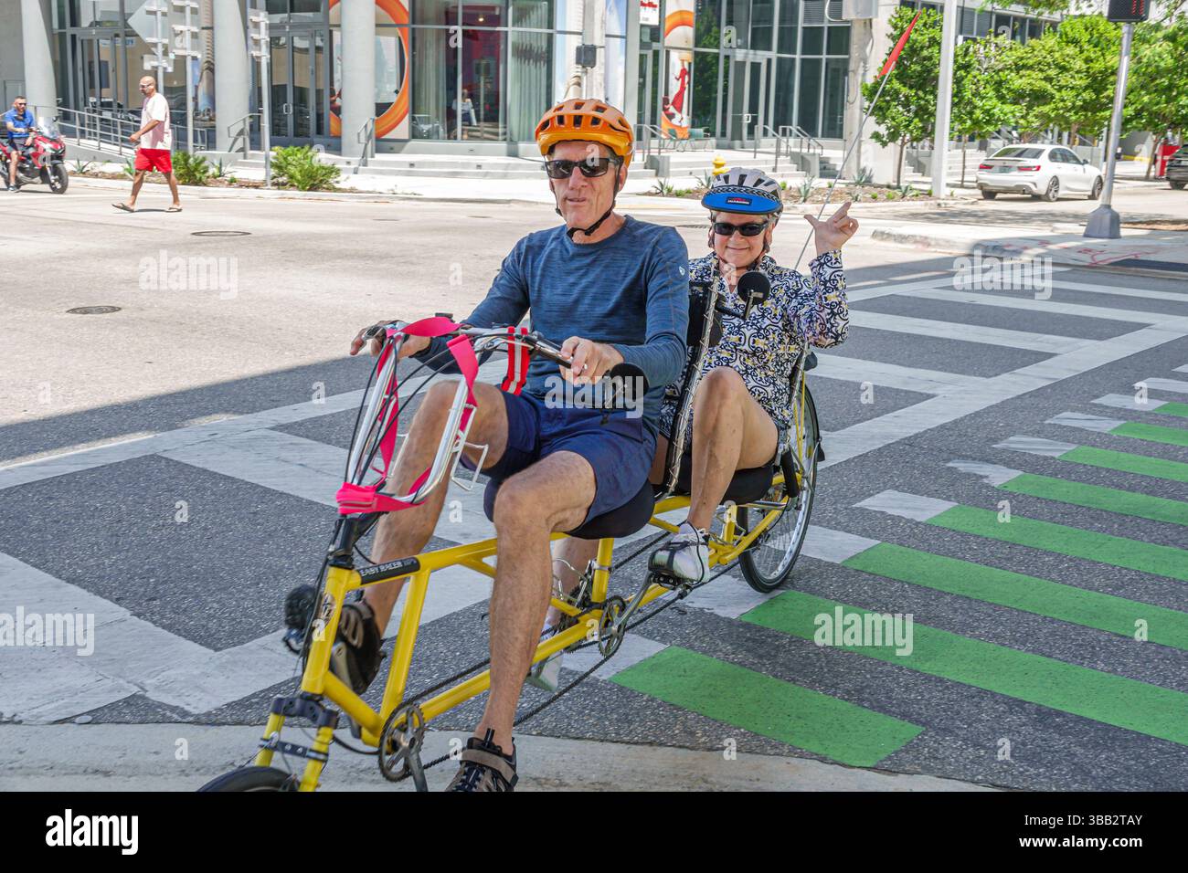 Miami Floride, Brickell Financial District, SW 1st Avenue, le soulignement, couple senior homme femme tandem vélo ensemble, casques lunettes de soleil actif Banque D'Images