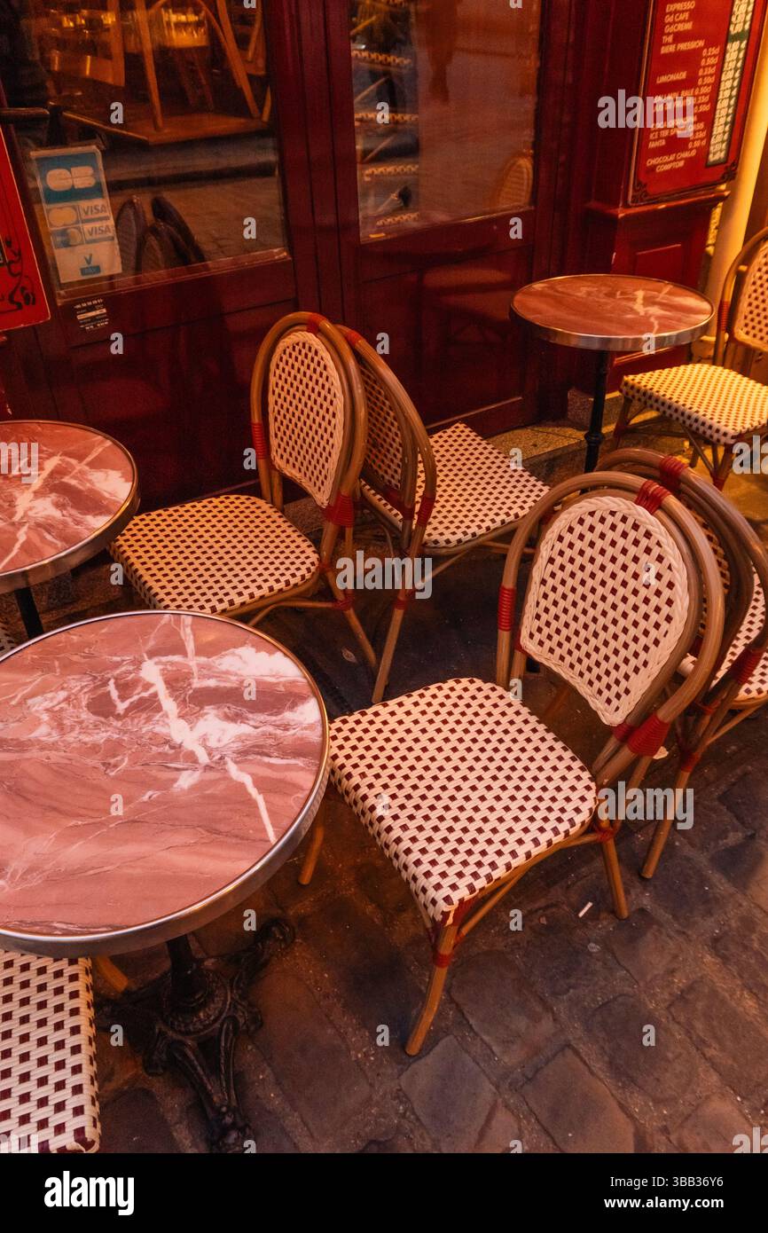 Café parisien d'ambiance avec éclairage d'ambiance rouge et chaises de bistrot Paris, France Banque D'Images