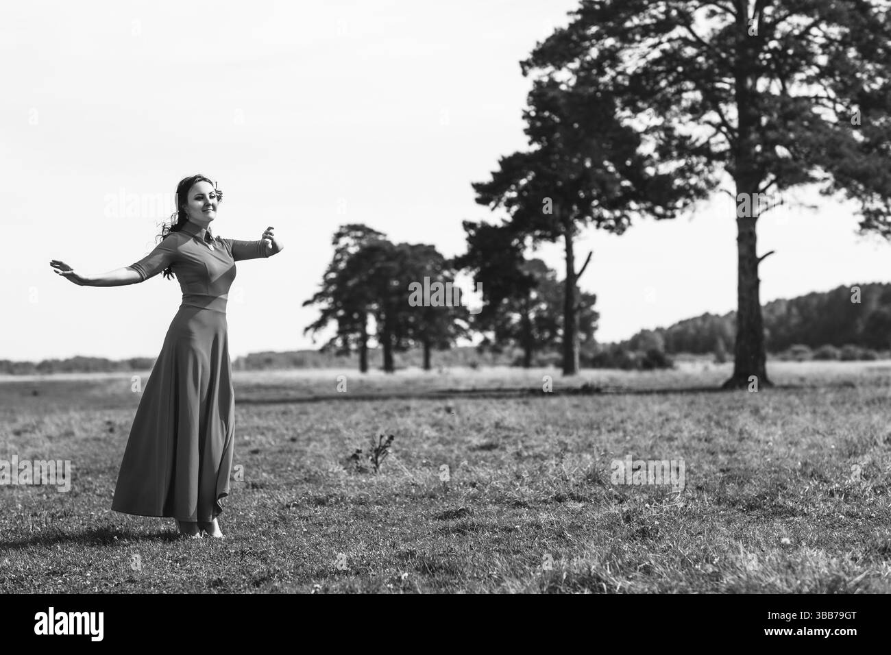 Femme mystérieuse en robe noire sur le terrain d'été Banque D'Images