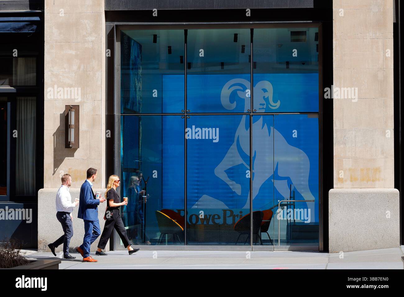 Des gens tenant des tasses à café marchant devant le bureau T Rowe Price au 233 Park Ave South, New York City. Banque D'Images