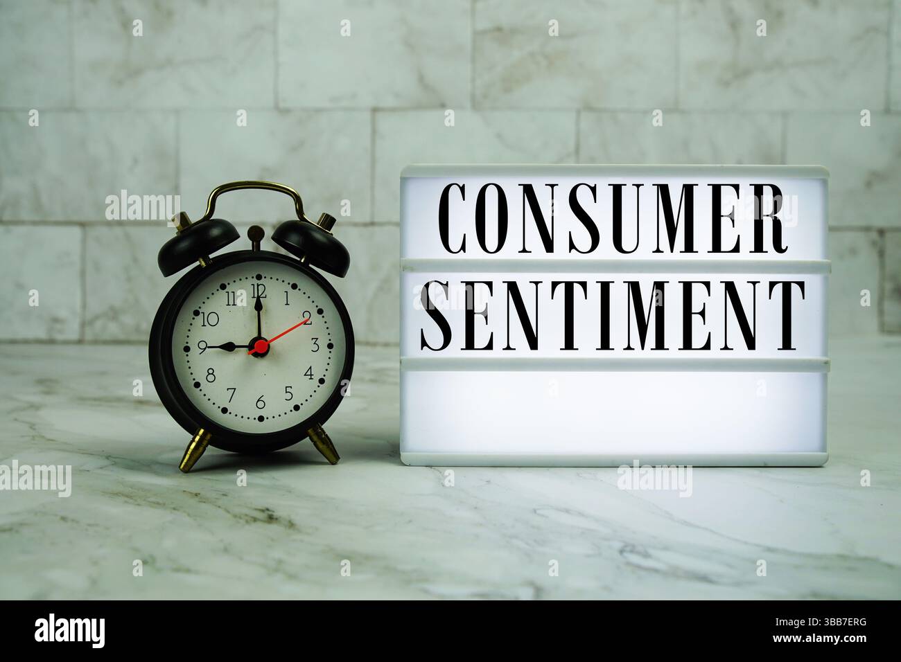 Texte de sentiment du consommateur sur la visionneuse LED avec réveil sur fond de marbre Banque D'Images