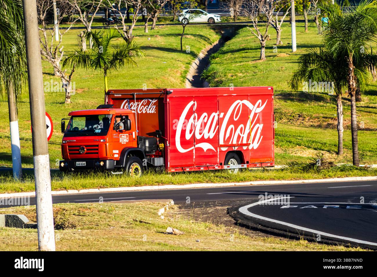 Marília, Sao Paulo, Brésil. 27 février 2025. Camion de livraison Coca-Cola FEMSA conduisant à travers une avenue dans une zone urbaine verte dans la ville de Marilia, illustr Banque D'Images