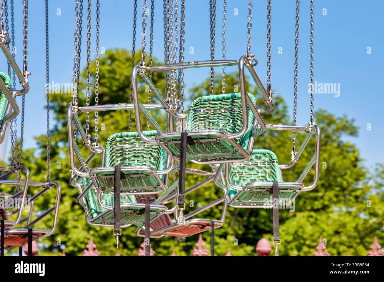 Chaises de carrousel pivotantes colorées contre Blue Sky – fond de tour de parc d'attractions Banque D'Images