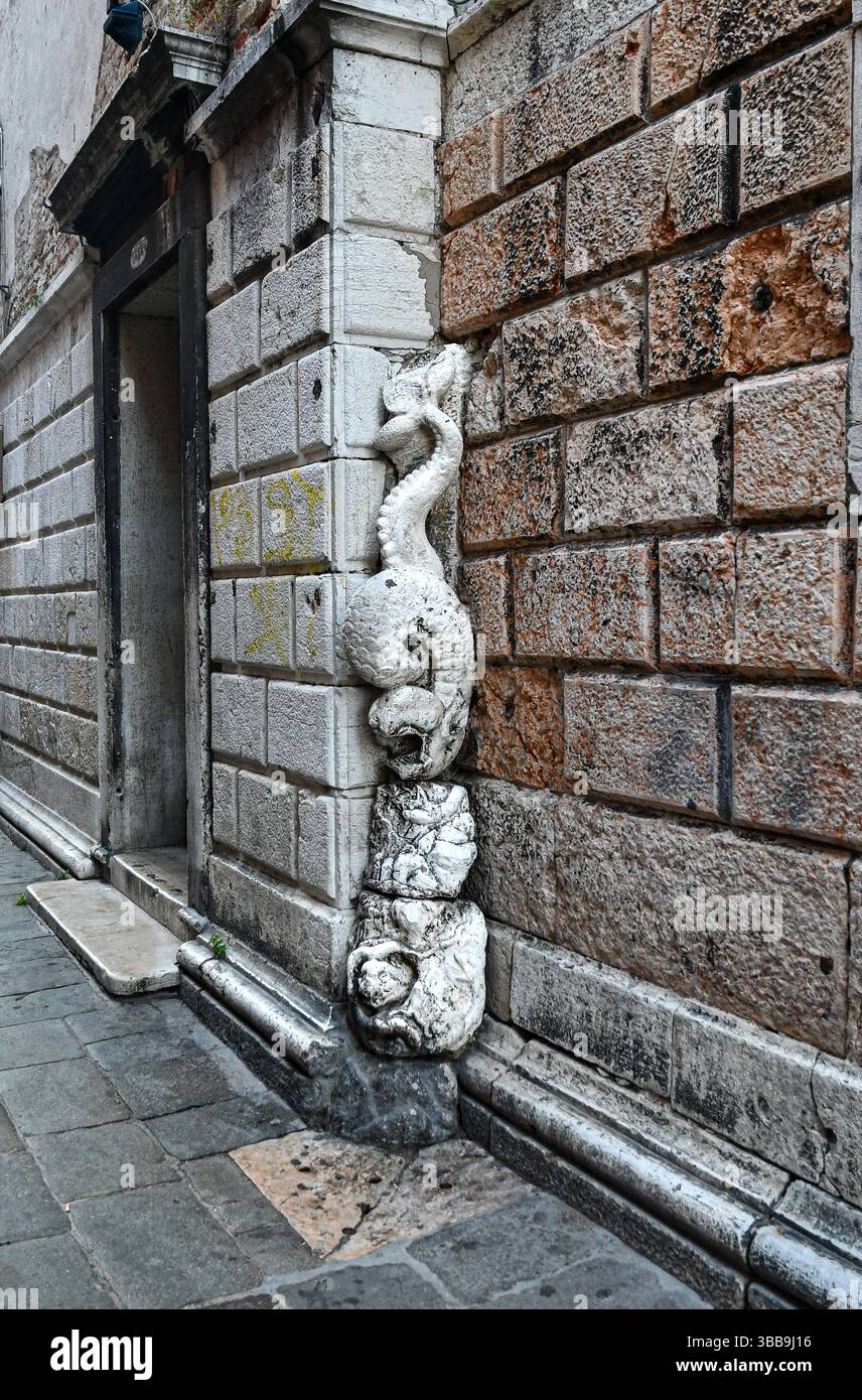 Extérieur de l'ancienne église de Santa Margherita avec un haut-relief de créatures mythologiques (serpents de mer et une tortue ?), Venise, Vénétie, Italie Banque D'Images
