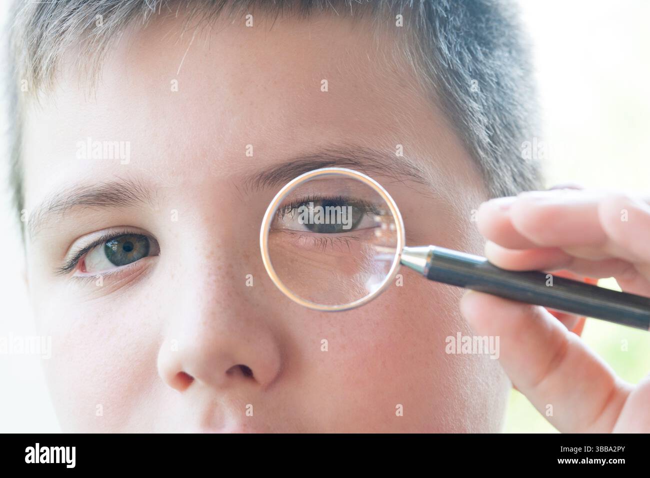 Garçon regarde à travers la loupe Banque D'Images