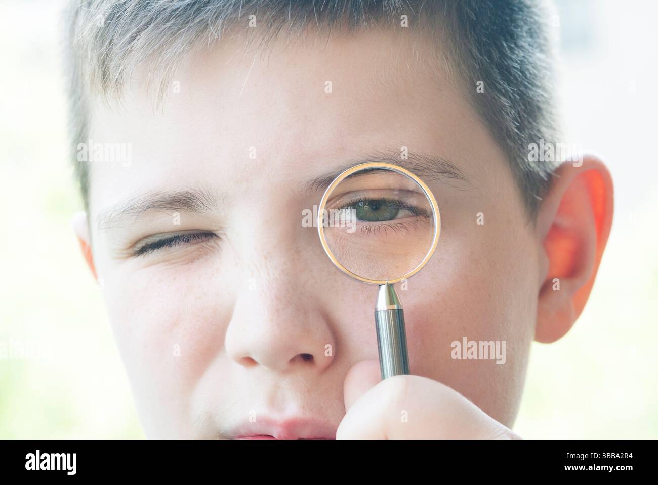 Garçon regarde à travers la loupe Banque D'Images