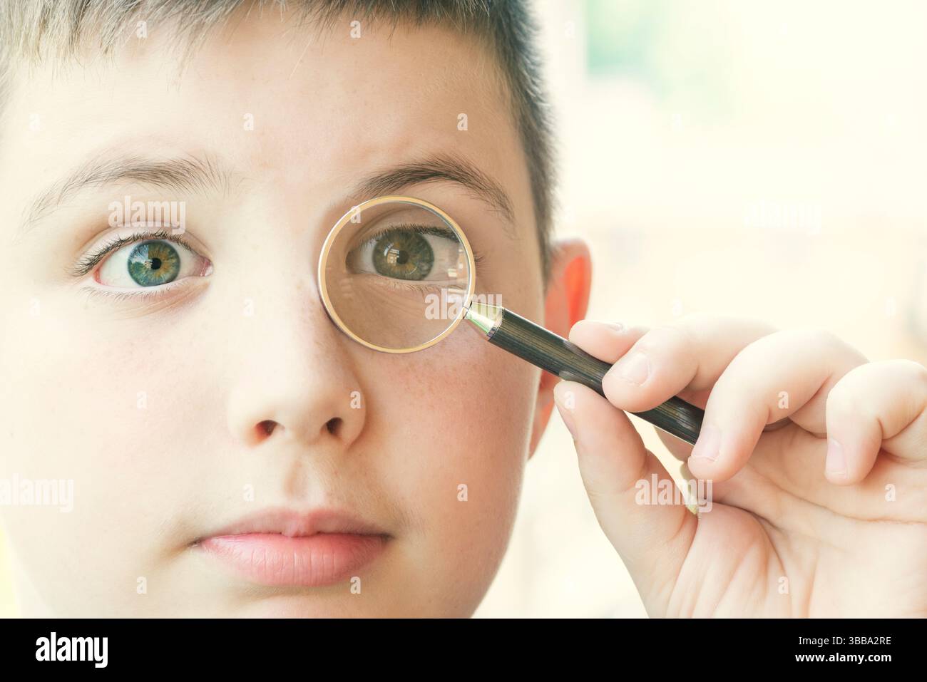 Garçon regarde à travers la loupe Banque D'Images