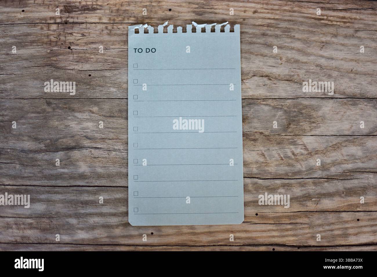 Pour faire liste papier de note vierge sur fond en bois. Liste de travail vue de dessus page vide de carnet de notes sur la table en bois. Espace de copie concept d'organiseur minimal simple Banque D'Images