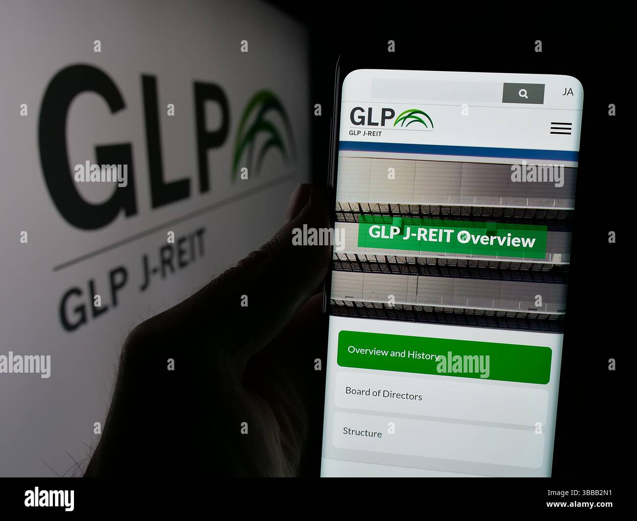 Stuttgart, Allemagne - 01-02-2024 : personne tenant un smartphone avec la page web de la société immobilière japonaise GLP J-REIT sur l'écran devant le logo. Banque D'Images