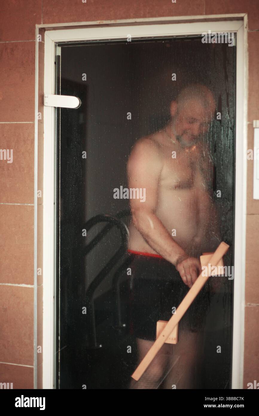 Contenu homme se relaxant dans un sauna Banque D'Images