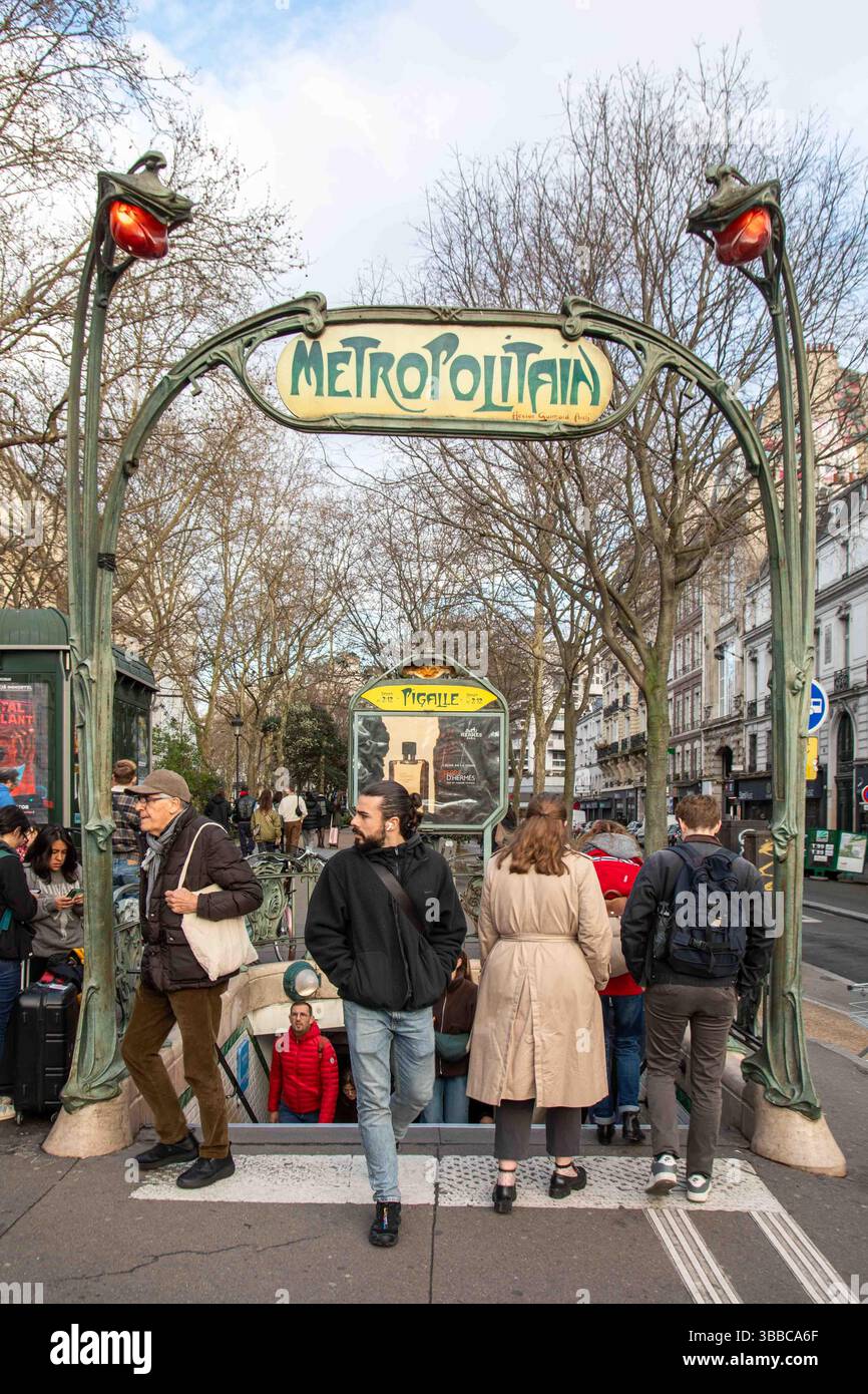Passagers entrant et sortant de la station de métro Pigalle sous le panneau Art Nouveau par Hector Guimard dans le quartier de Montmartre à Paris, France Banque D'Images