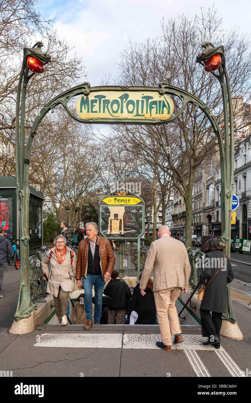 Passagers entrant et sortant de la station de métro de Pigalle sous le panneau Art Nouveau Metropolitain par Hector Guimard à Paris, France Banque D'Images