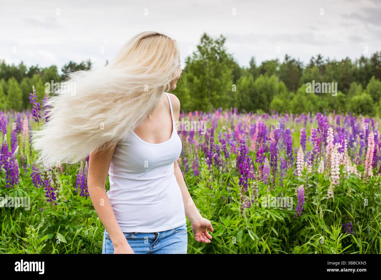 moscou, russie, 13.07.2017 Une femme blonde aux cheveux longs marche dans un champ de fleurs violettes. La scène est paisible et sereine, comme la femme le prend Banque D'Images